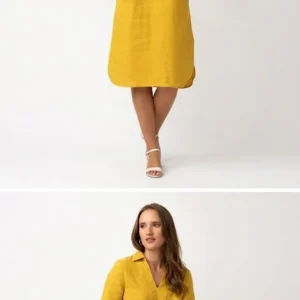 A woman sits on a bench wearing a yellow linen smart casual dress.
